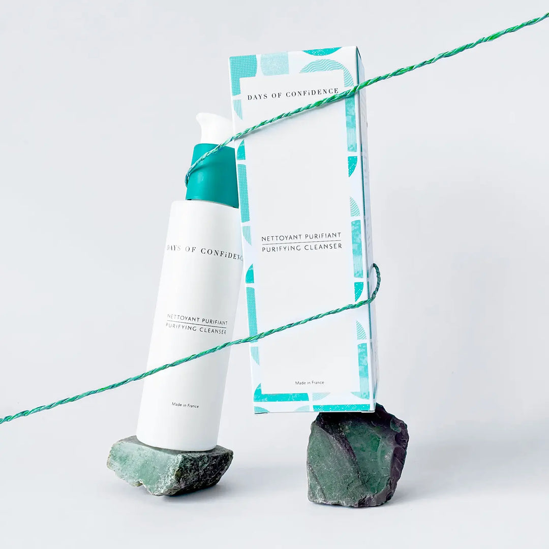 photo packshot sur fond blanc packaging éco responsable nettoyant visage detox purifiant doux détox boite blanche et verte sur cristaux pierre verte avec ficelle verte qui les tient