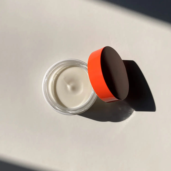 photo vue d’en haut de l’intérieur du packaging blanc et rouge de la crème hydratante visage bouclier urbain de la marque de beauté et bien être holistique days of confidence sur un fond blanc